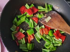 锅内的底油，放入青椒，红椒，翻炒。