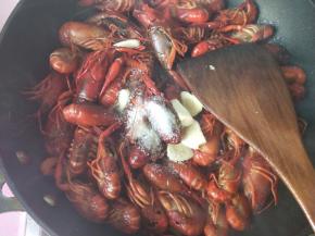 放入料酒，大蒜，白糖，盐，翻炒。