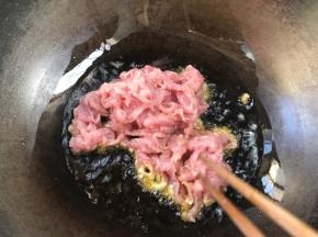 锅烧热油，放入腌制好的瘦肉，炒至变色