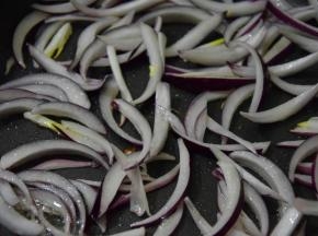 锅中再次倒入油，倒入洋葱条炒至变色