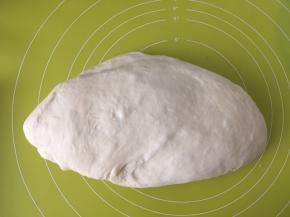 将面团取出，倒在揉面垫上按压排气