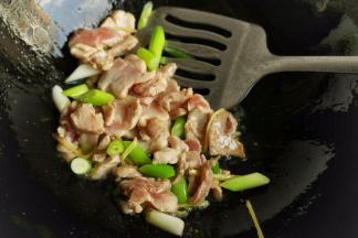 炒锅放入色拉油，热锅冷油放入葱姜爆香，再放入肉片滑炒，等到肉片变色。