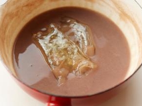 煮好的红豆浆晾凉至温热。吉利丁提前用冷水泡软，等到红豆浆至温热的时候放入泡软的吉利丁，搅拌均匀使吉利丁融化。