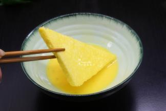 把切好的面皮片，放入蛋液中，均匀裹上鸡蛋液，快速夹起；