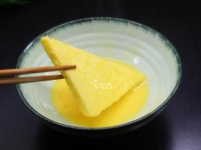 把切好的面皮片，放入蛋液中，均匀裹上鸡蛋液，快速夹起；