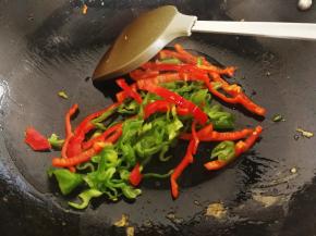 锅里放油，大火烧至八分热时倒入青红辣椒翻炒一下
