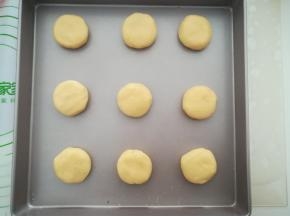 把面团放入烤盘中，压成圆饼状。