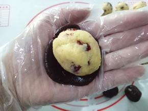 一个巧克力饼皮按扁，放入奶酪椰蓉内馅。