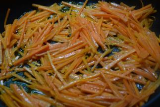 锅里留油，倒入胡萝卜丝，加入少许清水翻炒至变软