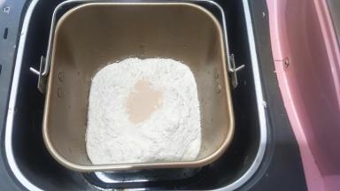 把面团部分中除黄油以外的所有材料称量好，放入容器中，启动揉面程序，开启一个和面程序