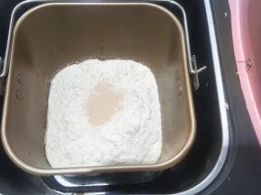 把面团部分中除黄油以外的所有材料称量好，放入容器中，启动揉面程序，开启一个和面程序