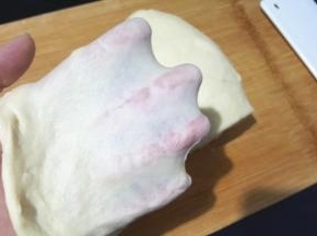 揉好的面团取出，放案板上摔一摔，揉一揉，揉出手套膜