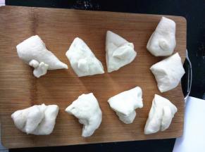 将发酵好的面团取出，轻压排气，平均分成9份。