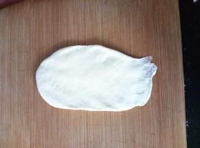 翻面后，压薄底边，自上而下卷起。