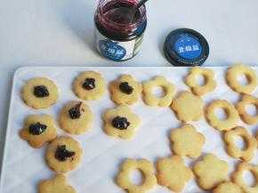 饼干烘烤好取出放凉，在一片实心饼干上面加入蓝莓，空心饼干重叠即可