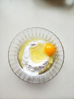 将鸡蛋仔预拌粉放在碗里，放入鸡蛋和植物油。