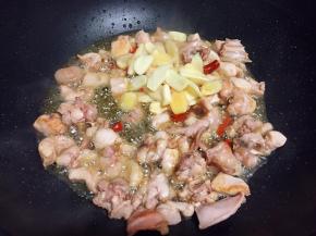 放入兔肉翻炒变色，再加入泡椒、泡姜、大蒜翻炒出香味。