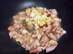 放入兔肉翻炒变色，再加入泡椒、泡姜、大蒜翻炒出香味。