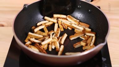 锅中再次加少许的油，油热后加入香干，大火翻炒2分钟，