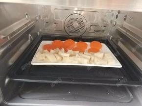 将藕丁和胡萝卜片一起放入蒸箱中蒸十五分钟