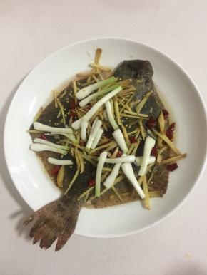 生姜切成丝，葱白切成段，干辣椒切成段撒在多宝鱼身上。