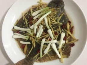 生姜切成丝，葱白切成段，干辣椒切成段撒在多宝鱼身上。