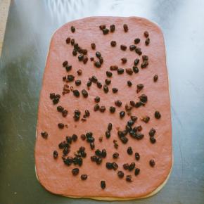 两片叠在一起，均匀的铺上蜜豆，卷起，收口朝下放入模具。