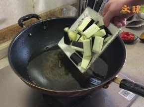 锅烧热，加入适量食用油，大火加热至6成热（手放在油上方10cm左右，感觉到有热气时）倒入茄子进行炸制