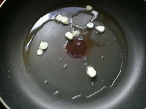 锅烧热后，加入10克花生油煸炒蒜瓣。