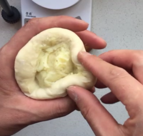 填入50克的馅料，收口收紧，放至35度环境下，同时放杯热水增加湿度，进行第二次发酵