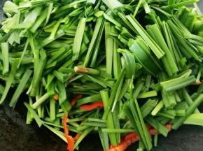 倒入韭菜和红辣椒翻炒至韭菜变色