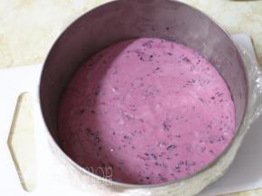 取出冷藏的饼干底。倒入深紫色的芝士糊，轻轻晃平表面，如果有气泡，就用牙签戳破。之后放入冰箱冷冻8分钟。