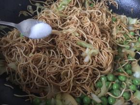 放入熟豌豆，少许的盐，翻炒均匀。