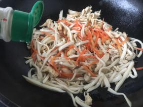 将锅洗干净，烧热，放入20ml的油，当油温4或者5成热时放入姜丝、葱花煸炒出香味，放入鸡丝、杏鲍菇丝、胡萝卜丝，撒入少许的白胡椒粉，迅速煸炒。