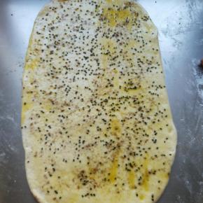 刷一层食用油，撒少许黑芝麻，少许椒盐，再撒一些干粉，卷起，切成小块