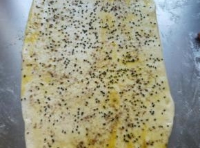 刷一层食用油，撒少许黑芝麻，少许椒盐，再撒一些干粉，卷起，切成小块