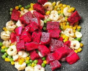 倒入红心火龙果，利用炒锅余温让红心火龙果释放出甜甜的果味。