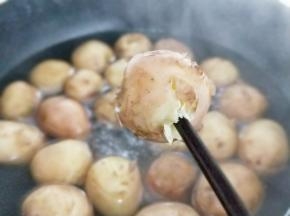 大火烧开，烧开后转中小火约8分钟，时间也要根据土豆的大小来调配，还可以用一根筷子扎一下，轻松扎透即可关火，将小土豆捞出淋干水分备用。