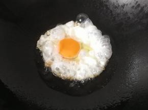 锅中倒入少许油烧热，打入一颗鸡蛋，小火煎制