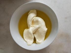 取一勺全蛋面糊加入融化的黄油中，用手动打蛋器混合均匀。