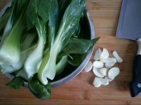 青菜从中间切开，方便快熟和入味，蒜切片。