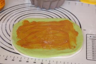 在绿色面团上方涂抹花生酱，四周不要涂抹