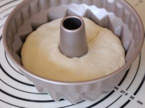 模具刷一层薄薄的油，防粘，放入面团，轻轻用手按压于模具温和