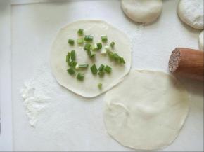 面团擀成饺子皮大小，在一个饺子皮上抹少许油，撒上少许盐和葱花。
