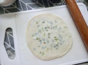 叠好的饺子皮，把它擀成一个大圆。