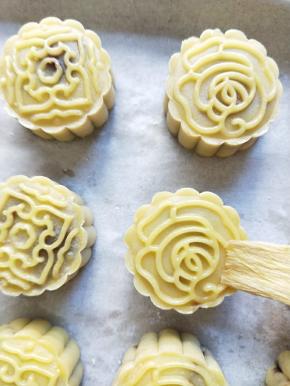 月饼表面喷微量水，放入预热好的烤箱，200度烤五分钟定型，再取出刷上一层薄薄的蛋黄水。