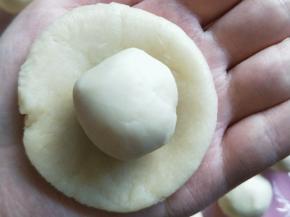 把油皮擀成圆形，再把油酥包在里面。