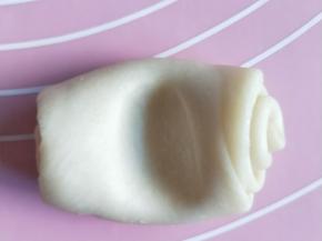 接着把第二次松弛好的面卷，用大拇指从中间压一个窝。