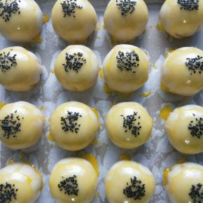 依次刷上蛋黄水，放进烤箱，150度烤五分钟定型，再取出，刷上一层蛋黄水，撒上芝麻。