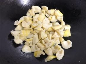 锅中倒入适量油，放入沥干水份的笋块，翻炒至微黄色。
